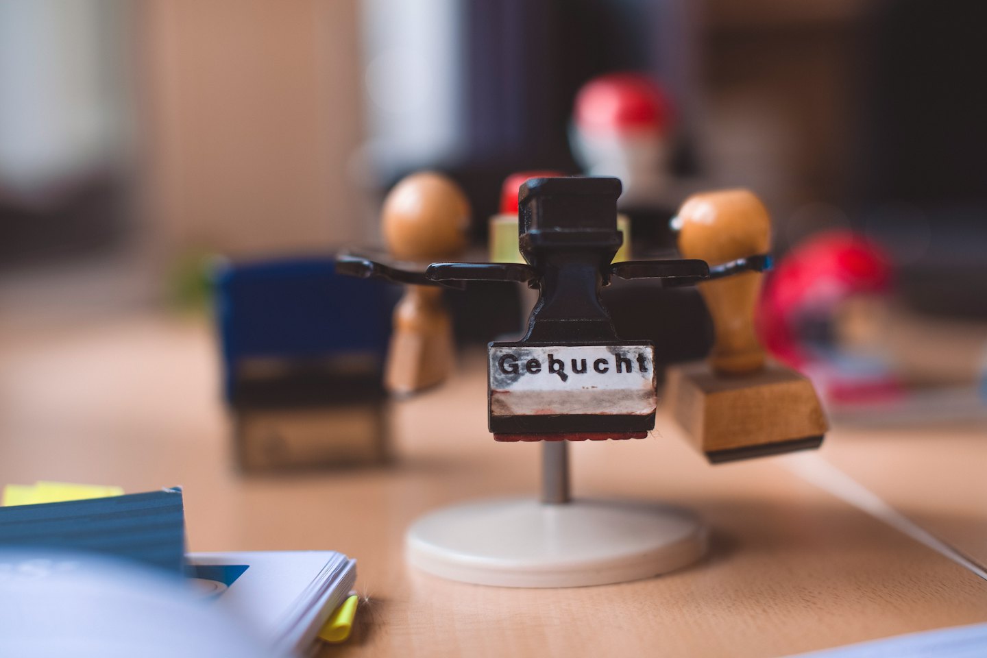 Desktop stamp holder with 'Gebucht' stamp.