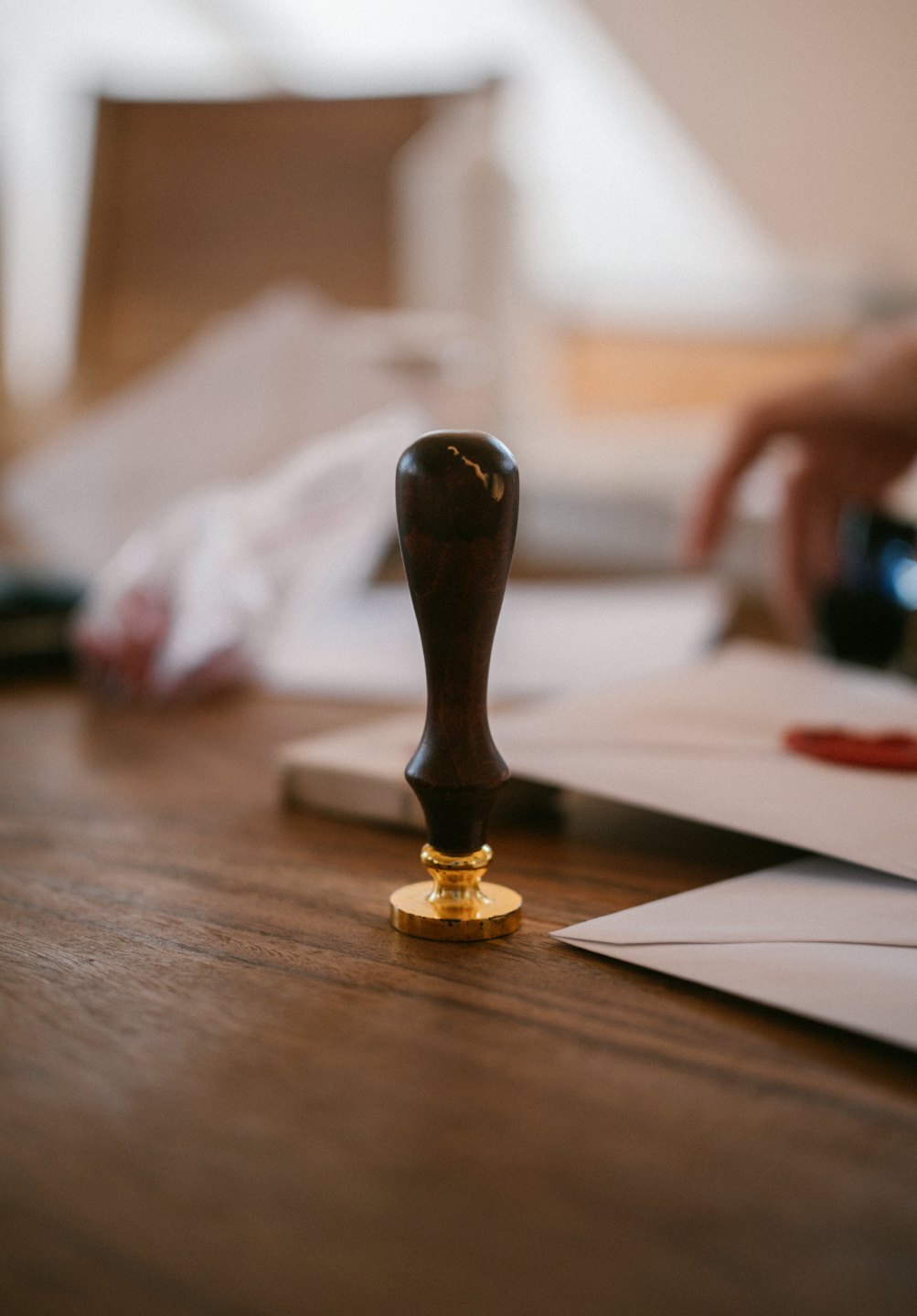 Wooden wax seal stamp on a desk preparing mail.